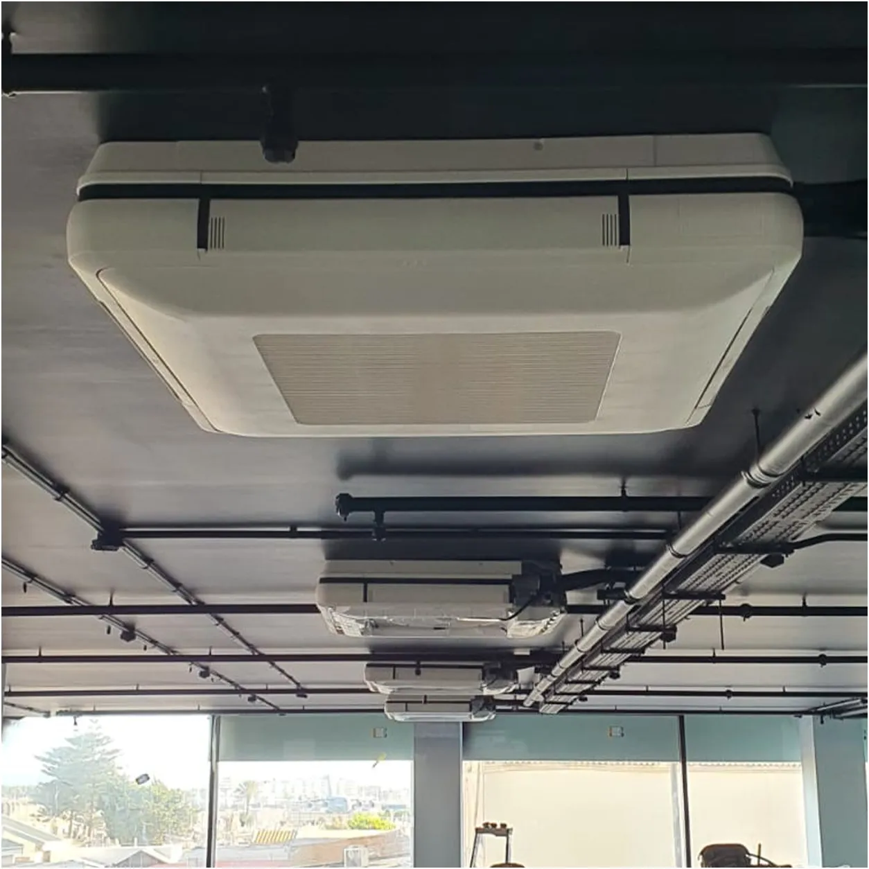Equipos de aire acondicionado tipo cassette instalados en el techo de una oficina